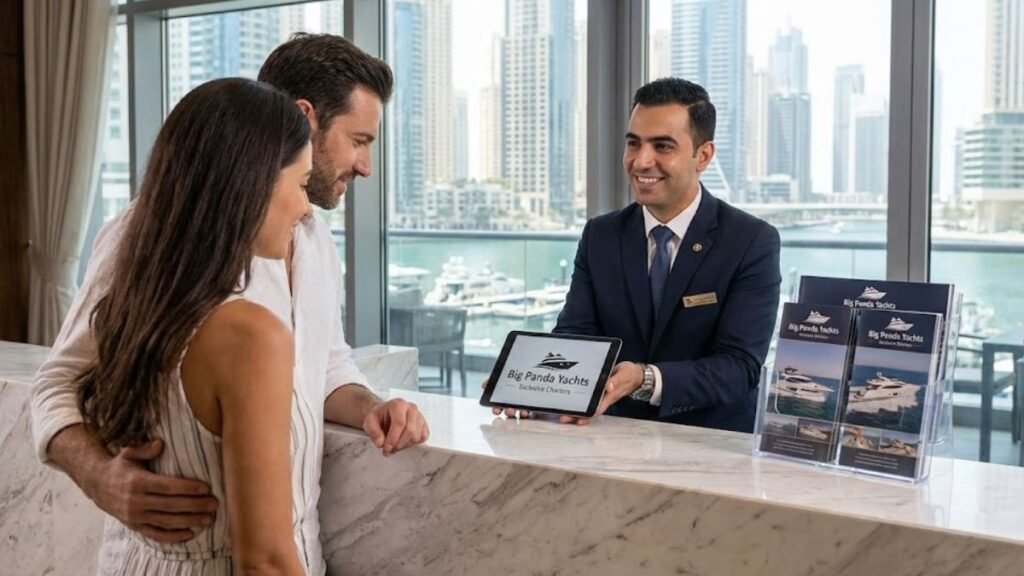 Hotel concierge at a luxury travel desk in Dubai presenting Big Panda Yachts rental packages on a tablet to a tourist couple, with branded brochures on display for B2B partnership.