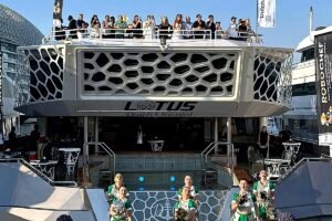 Front view of a luxury hospitality yacht in Abu Dhabi with guests watching Formula 1 events from the upper deck during the day